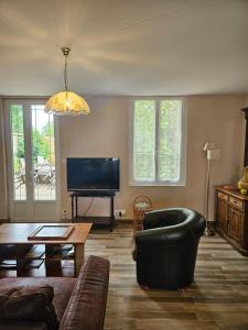 a living room with a couch and a television at Les Gîtes d'Argonne in Rarécourt