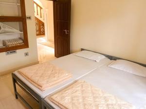a pair of beds in a bedroom with a mirror at Villa 9 degrees north in Sultan Bathery