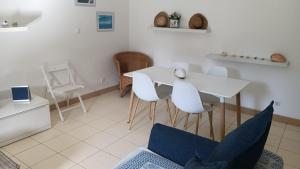a dining room with a white table and white chairs at Vida boa é no Vila Verde Sal in Santa Maria