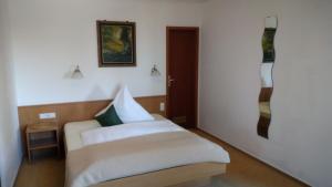 a bedroom with a bed and a picture on the wall at Kräuterhex' Reutin in Alpirsbach