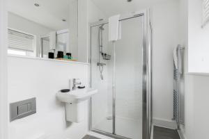 a white bathroom with a shower and a sink at Seas the Day - Moments from Hamworthy Beach and Park in Poole