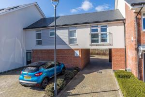 a blue car parked in front of a house at Seas the Day - Moments from Hamworthy Beach and Park in Poole +22 photos