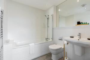 a white bathroom with a toilet and a sink at Seas the Day - Moments from Hamworthy Beach and Park in Poole