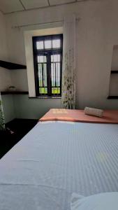 a large bed in a room with a window at Haputale Hills Holiday Home in Haputale