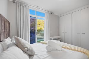 a bedroom with a white bed and a large window at White Waters in Cape Town +33 photos