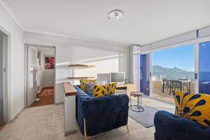a living room with a blue couch and a table at White Waters in Cape Town