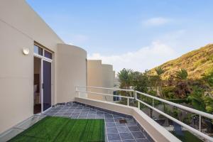 a balcony of a house with a green lawn at White Waters in Cape Town