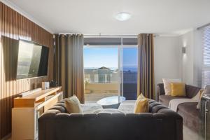 a living room with a couch and a tv at White Waters in Cape Town