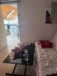 a room with a table and a bed and a mirror at Le belgique ,1 minute plage in Vallauris