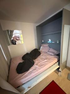 a unmade bed in a small room at Le belgique ,1 minute plage in Vallauris