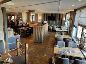 ein Restaurant mit Tischen und Stühlen in einem Raum in der Unterkunft Hotel Wernerwald - Restaurant, Wellness & Events in Cuxhaven