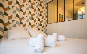 a bedroom with a white bed with towels on it at Le Parvis in Rodez