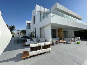 a white building with couches and tables on a patio at Seashell 2nd row sea Villa in El Alamein
