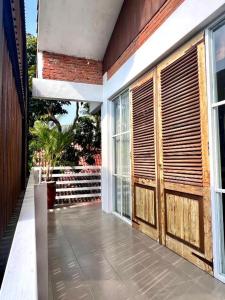 a porch with wooden doors on a house at PaddyView Hostel in Banyuwangi