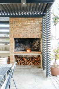 a brick fireplace with a fire in it at Lorelei Guest House in George