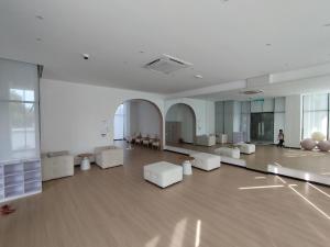 a room with white furniture and a person standing in it at Halimah Guesthouse in Putatan +5 photos
