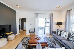 a living room with a couch and a coffee table at Lorelei Guest House in George +41 photos