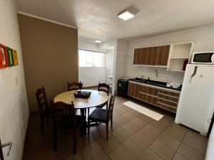 a kitchen with a table and chairs and a refrigerator at Apartamento de 3 Quartos com Ar Condicionado in Piracicaba
