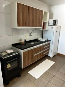 a kitchen with a stove and a refrigerator at Apartamento de 3 Quartos com Ar Condicionado in Piracicaba +4 photos