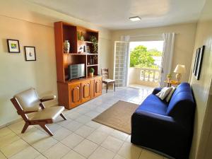 a living room with a blue couch and a chair at Apartamento de 3 Quartos com Ar Condicionado in Piracicaba