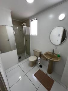a bathroom with a toilet and a sink and a mirror at Apartamento de 3 Quartos com Ar Condicionado in Piracicaba