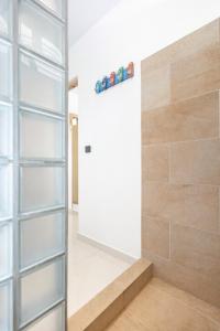 a walk in shower with a glass door at Moorea bungalow cosy proche plage de Temae in Moorea