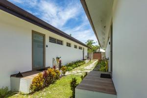 a house with a walkway next to a building at Moorea bungalow cosy proche plage de Temae in Moorea