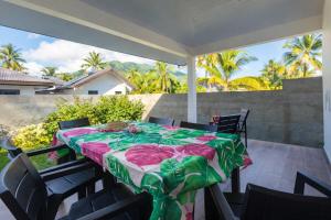 a table with a green and pink table cloth on a patio at Moorea bungalow cosy proche plage de Temae in Moorea