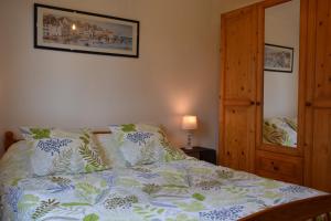 a bedroom with a bed with a white and green comforter at L'ESCALE SINAGOTE Gîte in Séné