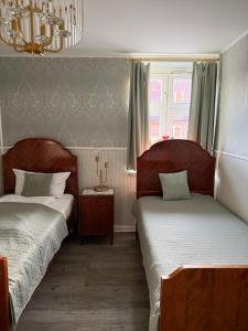 a bedroom with two beds and a chandelier at 2 SZ Ferienwohnung Hamburg zentral Parkplatz BoLA 24 in Hamburg