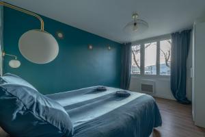a bedroom with a large bed with a blue wall at Appartement devant Nausicaa in Boulogne-sur-Mer