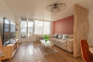 a living room with a couch and a table at Appartement devant Nausicaa in Boulogne-sur-Mer
