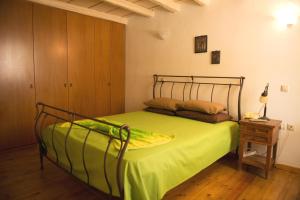 VóroiにあるArchontiko Voriのベッドルーム1室(緑のシーツとテーブル付)