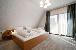 a bedroom with a bed with white sheets and a large window at Ferienwohnung mit Balkon in Rechlin
