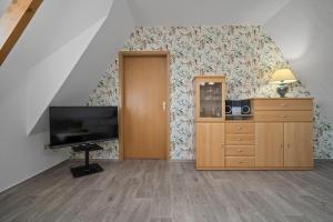 a living room with a flat screen tv and a dresser at Ferienwohnung mit Balkon in Rechlin