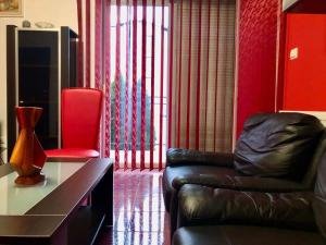 a living room with a leather couch and a red wall at Joy City Stay Calea Timisoarei 4 in Timişoara
