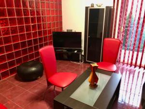 a living room with two red chairs and a table at Joy City Stay Calea Timisoarei 4 in Timişoara +27 photos