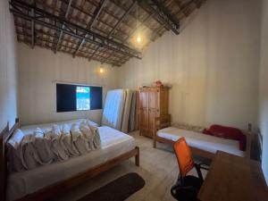a bedroom with two beds and a table and a tv at Chácara Conquistando II in Jarinu +16 photos