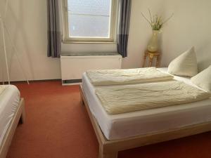 a bedroom with two beds and a window at Easy Stay Valencia in Oberboihingen