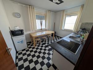 a kitchen with a black and white checkered floor at Easy Stay Valencia in Oberboihingen