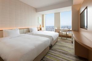 A bed or beds in a room at Nagoya JR Gate Tower Hotel