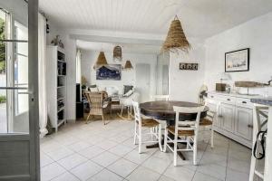 a kitchen and dining room with a table and chairs at L'écrin des Ormeaux - sur l'île - 300 m de la plage in Barbâtre