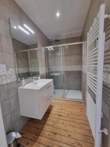 a bathroom with a white sink and a shower at Au Mont Chez Nous # Jacuzzi & Sauna # in Pontorson