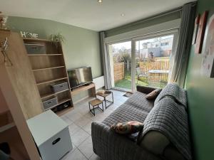 a living room with a couch and a large window at Le Petit Studio de Merlimont in Merlimont