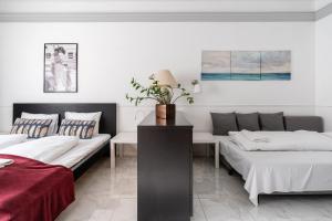 a bedroom with two beds and a table with a plant at Madach City Studio in Budapest
