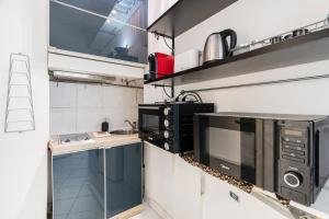 a small kitchen with a microwave and a stove at Madach City Studio in Budapest +12 photos