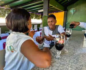 a group of people sitting at a table with wine glasses at Master Universel Hotel Bar Restaurant in Cap-Haïtien +22 photos