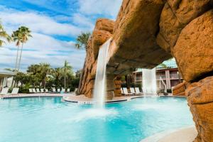a swimming pool with a waterfall in a resort at Radisson Resort at the Port in Cape Canaveral