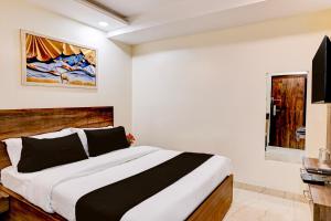 a bedroom with a large bed and a window at Townhouse OAK The Hotel Square Villa in Ghaziabad