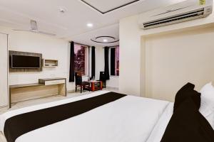 a hotel room with a bed and a television at Townhouse OAK The Hotel Square Villa in Ghaziabad